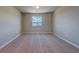 A bedroom with neutral carpet and walls, plus a window offering plenty of natural light and mountain views at 16858 Greyhawk Dr, Monument, CO 80132