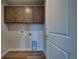 Spacious laundry room featuring wood floors, storage cabinets, and a utility sink at 16858 Greyhawk Dr, Monument, CO 80132