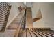 Open staircase with wood railing and black iron balusters leading to the upper level of the home at 16858 Greyhawk Dr, Monument, CO 80132