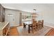Open dining room featuring a rustic wood table set with chairs, an overhead light fixture, and wood flooring at 13905 W 21St Ave, Golden, CO 80401