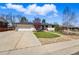 Charming single-story home with a well-manicured lawn, mature trees, and a large driveway at 13905 W 21St Ave, Golden, CO 80401