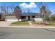 Charming single-story home with a well-manicured lawn, mature trees, and a two-car garage at 13905 W 21St Ave, Golden, CO 80401
