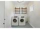 Laundry room with front load washer and dryer, blue patterned tile flooring, and wood shelving at 13905 W 21St Ave, Golden, CO 80401
