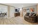 Living room with wood-look floors, a round chair, and a view into an adjacent bedroom at 13905 W 21St Ave, Golden, CO 80401