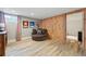 Cozy living room featuring wood-look floors, a round chair, and a unique wood panel wall at 13905 W 21St Ave, Golden, CO 80401
