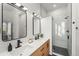 A stylish bathroom boasts double sinks, wood cabinets, and a glass-enclosed shower at 2318 Arapahoe St, Denver, CO 80205