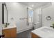 Modern bathroom with dual sinks, sleek fixtures, a glass-enclosed shower, and a window for natural light at 2318 Arapahoe St, Denver, CO 80205
