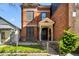 Charming brick two-story home featuring a welcoming front entrance, well-maintained landscaping, and a fenced yard at 2318 Arapahoe St, Denver, CO 80205
