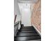 Modern stairway with a unique light fixture and exposed brick wall adding architectural interest at 2318 Arapahoe St, Denver, CO 80205