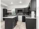 Modern kitchen with black cabinets, subway tile backsplash, quartz countertops, and stainless appliances at 400 Division Blvd, Platteville, CO 80651