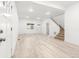 Bright living room featuring wood-look floors, white walls, and a staircase to the second floor at 400 Division Blvd, Platteville, CO 80651