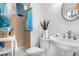 Bathroom with a pedestal sink, toilet, and a shower featuring blue towels at 977 S Salida St, Aurora, CO 80017