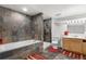 Modern bathroom with a large tub, tiled shower, and wooden vanity with a sink at 977 S Salida St, Aurora, CO 80017