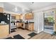 Well-lit kitchen featuring stainless steel appliances, wood cabinets, and access to the backyard at 977 S Salida St, Aurora, CO 80017