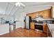 An open kitchen concept with stainless steel appliances, hardwood floors, and a ceiling fan providing a comfortable cooking area at 961 S Miller Way, Lakewood, CO 80226