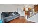 The gray couch, hardwood flooring, and a partial view into the kitchen highlight the warm ambiance of the living area at 961 S Miller Way, Lakewood, CO 80226