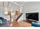 Open-concept living area featuring hardwood floors, a staircase, and views into the kitchen at 961 S Miller Way, Lakewood, CO 80226