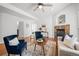 Bright living room features a fireplace, wood floors, ceiling fan, two chairs and access to other rooms at 8603 E Dry Creek Rd # 214, Englewood, CO 80112