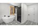 Modern bathroom featuring a soaking tub, glass shower, and stylish black-and-white patterned tile floor at 9350 W Florida Ave, Lakewood, CO 80232