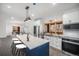 Bright kitchen with white cabinets, blue island, stainless steel appliances, and views to living and dining areas at 9350 W Florida Ave, Lakewood, CO 80232