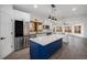 Gourmet kitchen boasts stainless appliances, white cabinets, an island with breakfast bar, and hardwood flooring at 9350 W Florida Ave, Lakewood, CO 80232