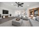 Open-concept living room with gray furniture, wood-look floors, natural light, and views to the kitchen at 9350 W Florida Ave, Lakewood, CO 80232