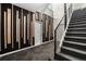 Modern stairway with gray carpet, black railings, and a decorative wood accent wall adds sophistication to this home at 9350 W Florida Ave, Lakewood, CO 80232