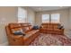 Comfortable living room with leather sofas, decorative pillows, and a vibrant patterned rug at 6172 N Liverpool St, Aurora, CO 80019