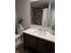 Stylish bathroom features a dark wood vanity with a white countertop and a shower with tile surround at 561 E Geneva N St # 103, Aurora, CO 80010