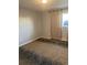Bedroom with patterned carpet, neutral wall color, and a window with outside light and view at 561 E Geneva N St # 103, Aurora, CO 80010