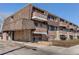 Multi-level condo building featuring brick facade, balconies, and a covered entrance at 561 E Geneva N St # 103, Aurora, CO 80010