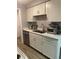 Bright kitchen features white cabinets, stainless steel dishwasher, and a double sink at 561 E Geneva N St # 103, Aurora, CO 80010