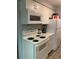 Well-lit kitchen with white cabinets, a four-burner electric range, and essential appliances at 561 E Geneva N St # 103, Aurora, CO 80010