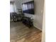 Living room with wood-look floors, television, and dog kennel at 561 E Geneva N St # 103, Aurora, CO 80010
