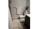 A white toilet sits beneath a decorative houseplant and a towel rack with towel in this quaint bathroom at 561 E Geneva N St # 103, Aurora, CO 80010