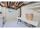 Unfinished basement space with laundry chute and white painted floor; great for storage and other possibilities at 6914 E Briarwood Dr, Centennial, CO 80112