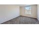 Simple bedroom with neutral walls, carpet, and a large window showing the roof at 6914 E Briarwood Dr, Centennial, CO 80112