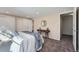 Bright bedroom with a console table, round mirror, and access to the bathroom and closet at 6914 E Briarwood Dr, Centennial, CO 80112