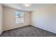 Plain bedroom with neutral walls, carpet, and a large window showing a roof at 6914 E Briarwood Dr, Centennial, CO 80112