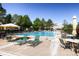 Community pool with ample seating, umbrellas, and well-maintained grounds, ideal for summer enjoyment at 6914 E Briarwood Dr, Centennial, CO 80112