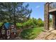 Charming backyard featuring lush greenery, a playhouse, and stone accents at 1575 Ridgetrail Ct, Castle Rock, CO 80104
