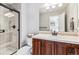 Well-lit bathroom with a walk-in shower, cherry wood cabinets, and a modern mirror at 1575 Ridgetrail Ct, Castle Rock, CO 80104
