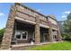 Multi-level home featuring a large outdoor deck, stone pillars, and a spacious backyard at 1575 Ridgetrail Ct, Castle Rock, CO 80104