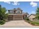 Inviting two-story home with a three-car garage, manicured lawn, and charming landscaping at 1575 Ridgetrail Ct, Castle Rock, CO 80104