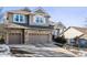 Two-story house with stone accents, two-car garage, and a landscaped yard at 1575 Ridgetrail Ct, Castle Rock, CO 80104