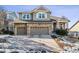 Two-story house with stone accents, two-car garage, and a landscaped yard at 1575 Ridgetrail Ct, Castle Rock, CO 80104