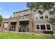 Spacious home featuring a large outdoor deck with stone pillars, and manicured lawn at 1575 Ridgetrail Ct, Castle Rock, CO 80104