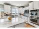 Bright kitchen featuring white cabinets, stainless steel appliances, and a marble countertop at 1575 Ridgetrail Ct, Castle Rock, CO 80104