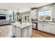 Open-concept kitchen featuring a center island, white cabinets, stainless appliances, and great natural light at 1575 Ridgetrail Ct, Castle Rock, CO 80104