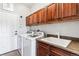 Well-organized laundry room with modern appliances, wood cabinets, and sink area at 1575 Ridgetrail Ct, Castle Rock, CO 80104